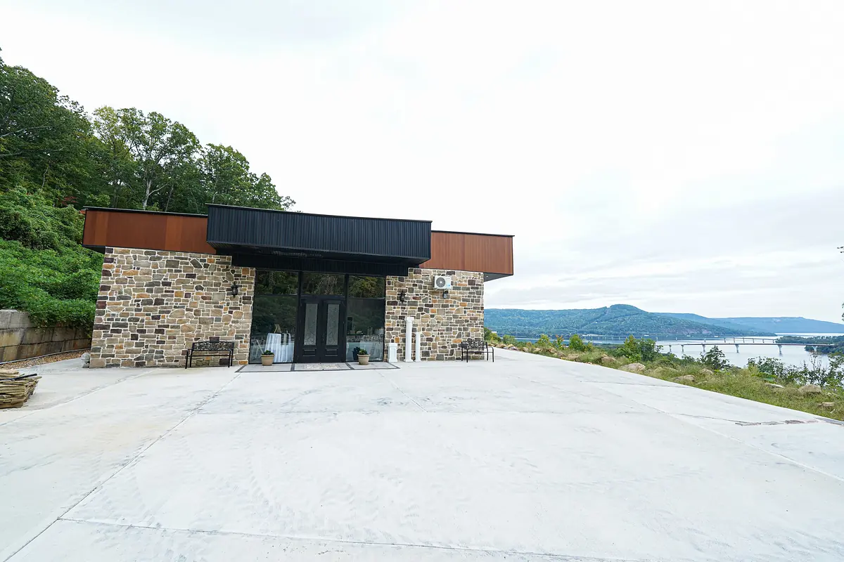 Stone-and-wood entrance at Lookout Winery with the lake and bridge behind