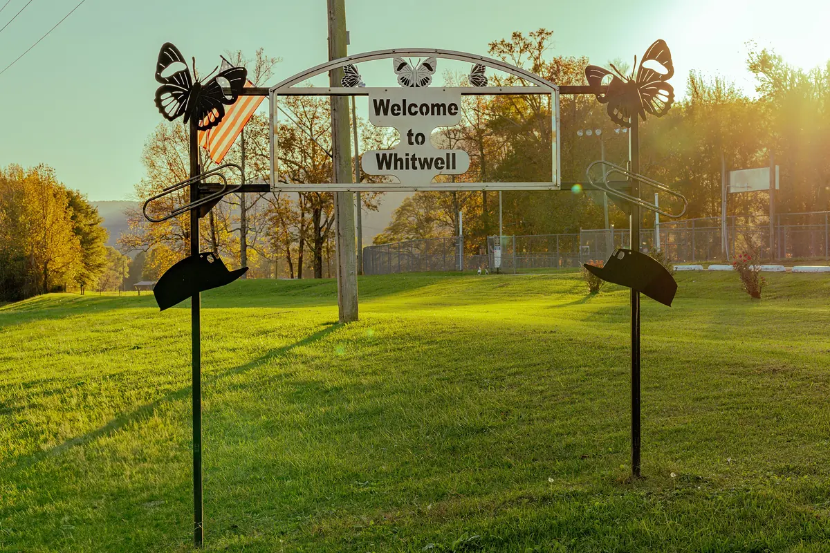 Whitwell welcome arch with butterfly cutouts and an American flag
