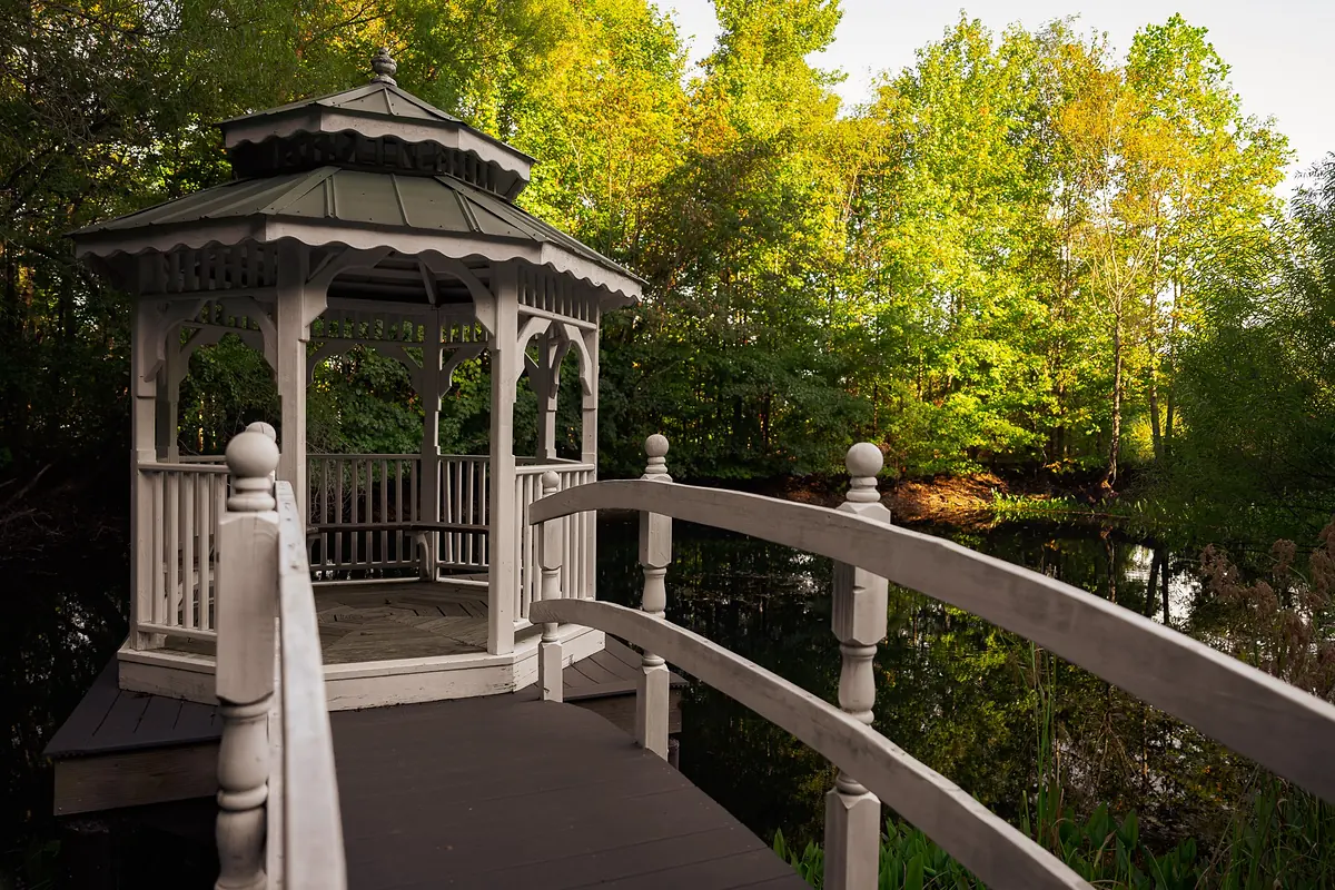 White gazebo over the pond at Mountain Willow Manor in fall