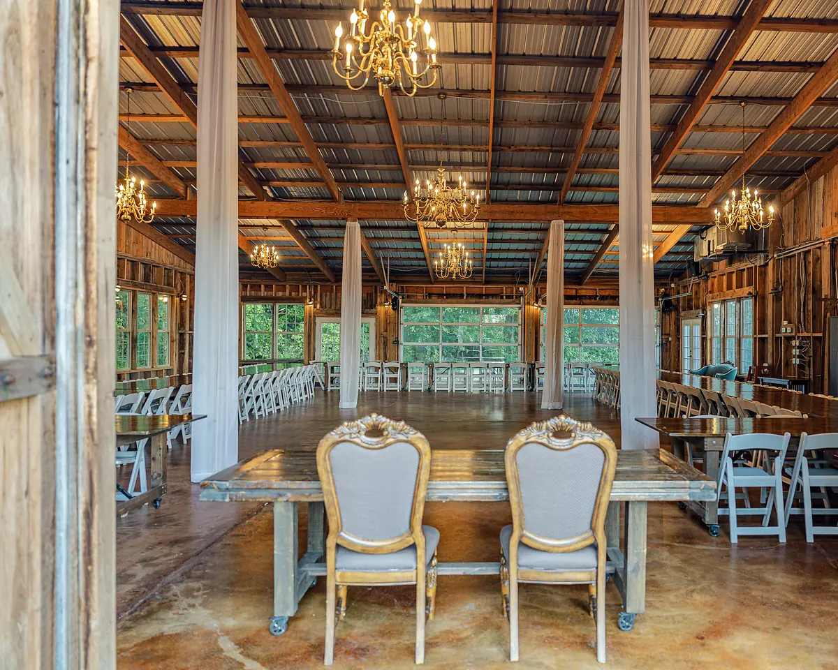 Mountain Willow Manor barn set for a reception with chandeliers and long tables