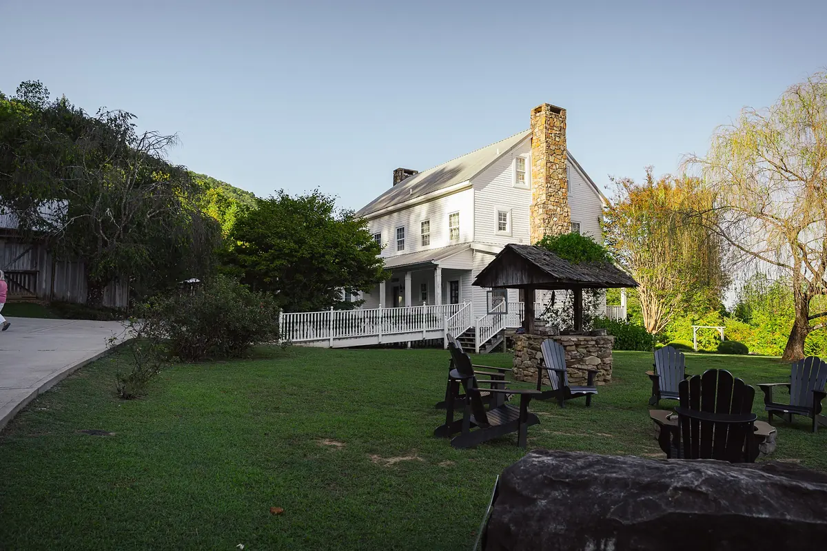 Mountain Willow Manor house with a stone chimney and a fire ring out front