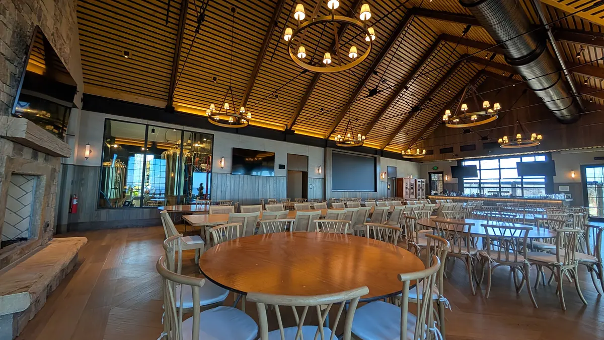 Riverdance great hall with a wood-slat ceiling, ring chandeliers and round tables